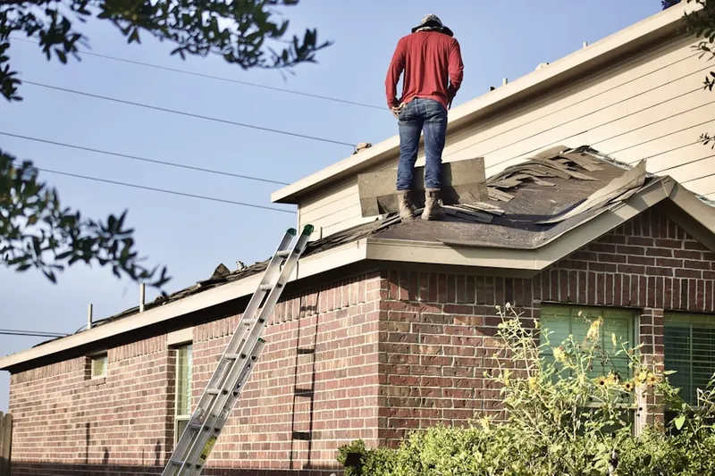Professional roofer working on a residential roof in Winchester Center